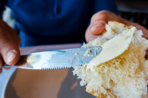 Cold butter, recently taken out of the deep freeze, and being spread onto bread.