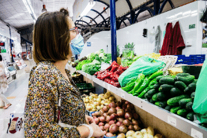 A woman shopping in a grocery store with a mask on.